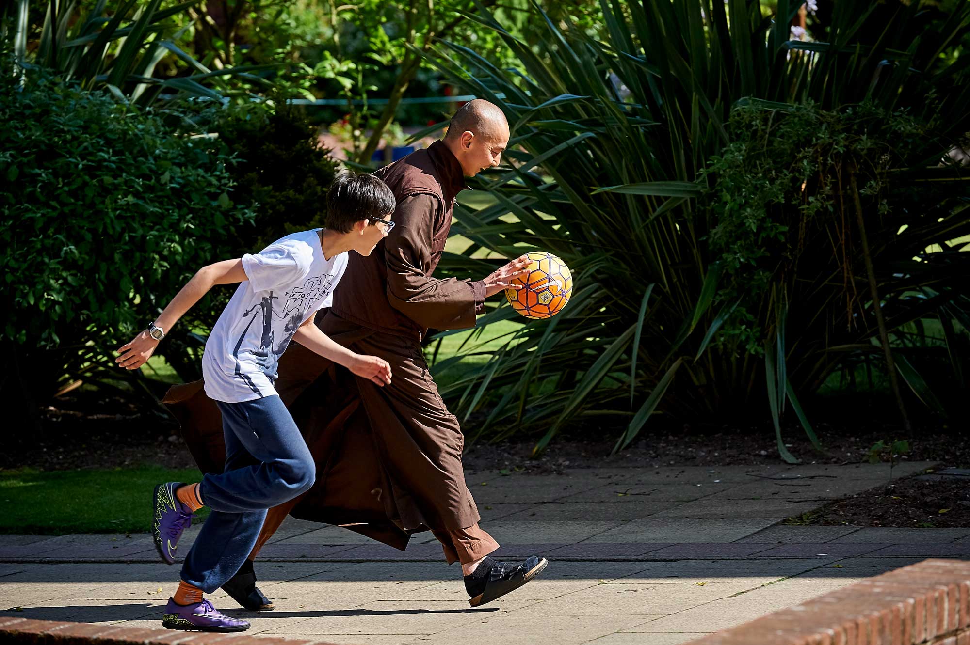Monastic and child playing basketball