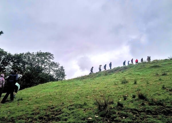 People walking up a hill during trip to Wales