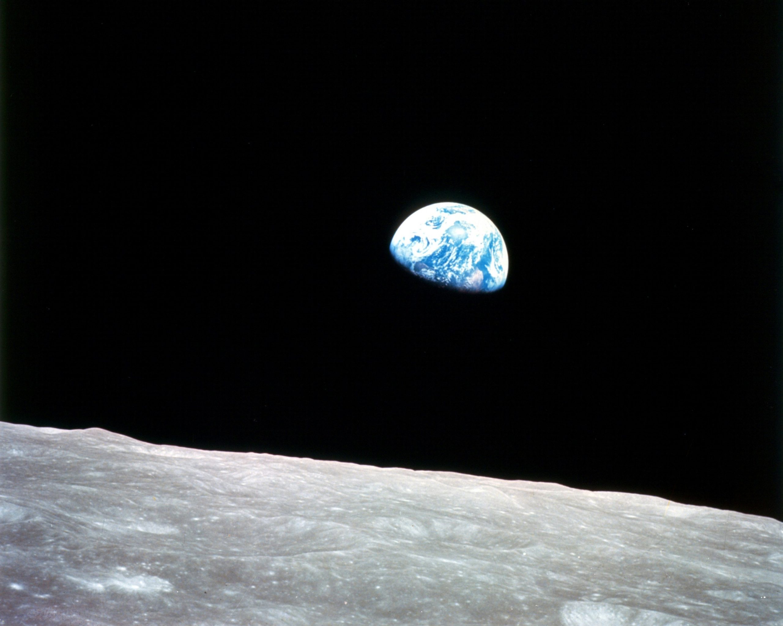 Earth rising above the horizon seen from the moon.