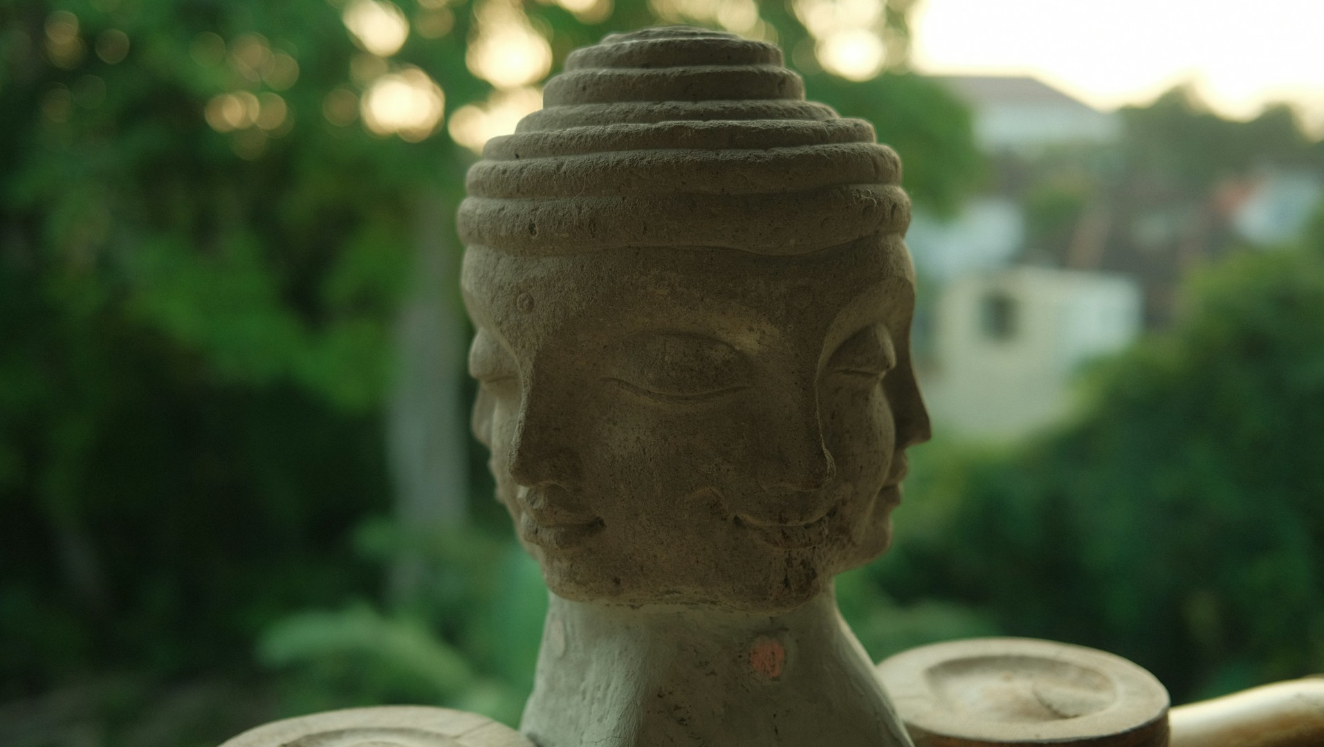 Stone statue of the head of a Buddha with three faces.