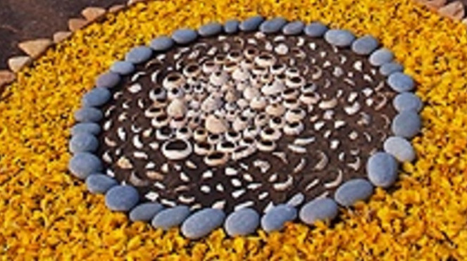 Representation of a sunflower made from coloured pebbles.